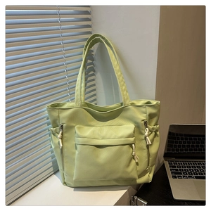 Detail of light green tote bag with multiple pockets and functional drawstring closure