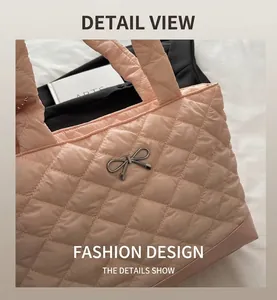 Close-up of pink quilted tote bag featuring a silver metal bow and puffer texture