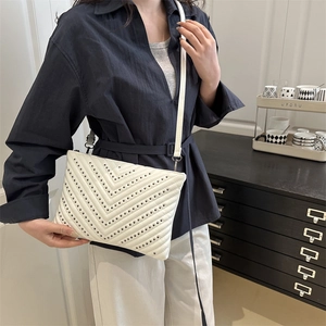Elegant white chevron quilted crossbody bag with black studs and top zipper detail