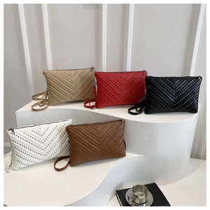 Macro detail of V-quilted faux leather crossbody bags with rivets in multiple colors