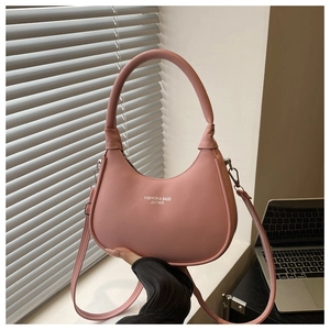 Detail of pink leather crescent bag with white fashion text and silver hardware