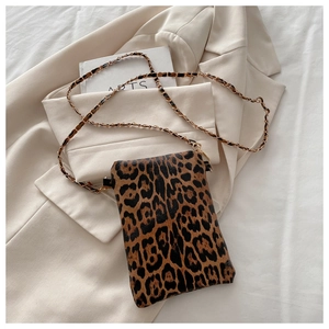 Detail shot of leopard print mini crossbody bag with gold metal chain strap and PU leather