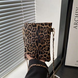 Detail of leopard print leather crossbody bag with elegant gold chain strap and stitching