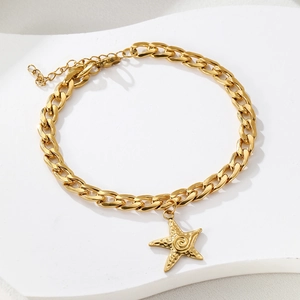 Detailed view of a gold curb chain anklet featuring a textured starfish charm pendant
