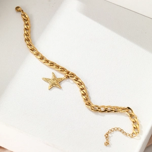 Detail of gold stainless steel starfish charm on a textured Cuban link chain anklet
