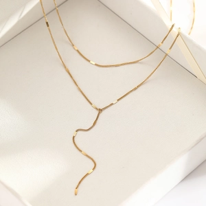 Detailed macro of gold-plated double-layer Y-shaped tassel necklace with flat sequins