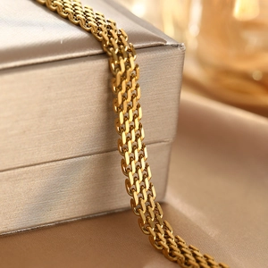 Macro detail of 18K gold-plated stainless steel multi-layered chain bracelet textures