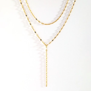 Détail du collier en Y doré avec maillons à paillettes élégants et style moderne tombant