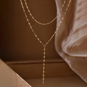 Détail macro du collier lariat en Y double couche plaqué or avec chaîne à lèvres
