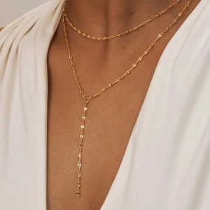 Détail d'un collier en Y doré à deux rangées avec des maillons plats effet paillettes