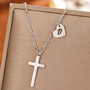Detailed shot of silver stainless steel cross necklace with a custom heart letter D pendant
