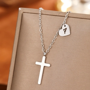 Detailed macro shot of silver stainless steel necklace with cross and heart number 7 pendant
