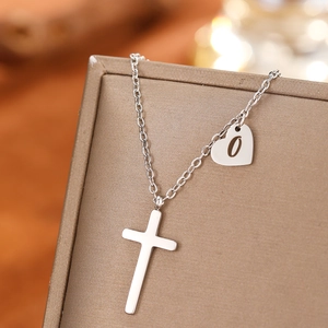 Detail of silver stainless steel cross necklace with engraved heart letter O pendant