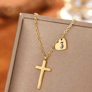 Detail of gold-plated stainless steel necklace with cross and number 3 heart pendant