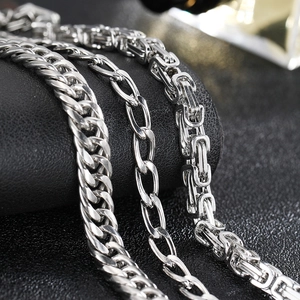 Polished stainless steel Cuban and Byzantine chains for men on black leather texture