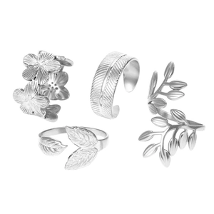 Detail view of adjustable silver steel rings featuring carved leaf, flower, and feather patterns