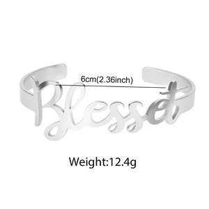 Macro detail of 'Blessed' cutout design on silver stainless steel open cuff bracelet
