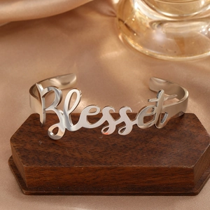 Detailed view of silver stainless steel open cuff bracelet with Blessed engraving