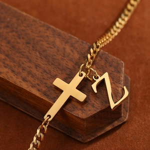 Macro shot of gold stainless steel anklet with cross and Z letter pendants