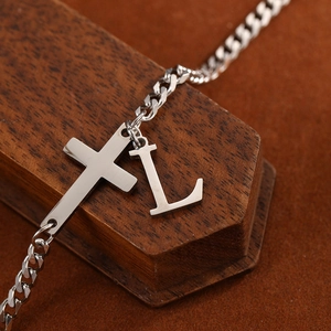 Detailed view of silver stainless steel Cuban link anklet with cross and letter L charms