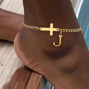 Gold stainless steel Cuban anklet featuring cross and letter J pendant on skin