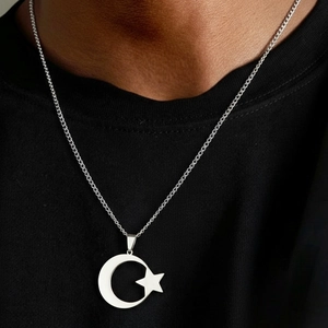 Collier en acier inoxydable avec pendentif lune et étoile porté sur un haut noir