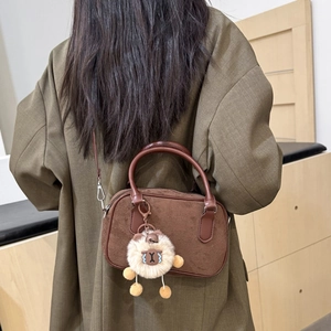 Sac bowling rétro en daim marron pour femme avec charm ours mignon porté par un mannequin