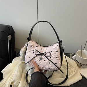 Sac à bandoulière rose matelassé avec nœuds noirs et pendentif cœur, style chic