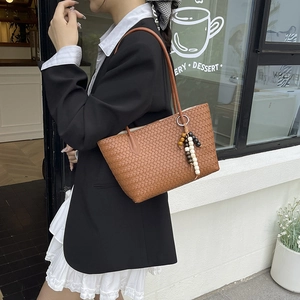 Brown woven leather tote bag with colorful bead tassel fringe shown on a fashion model