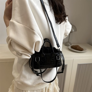 Chic black crocodile embossed mini crossbody bag with top handles and drawstring closure