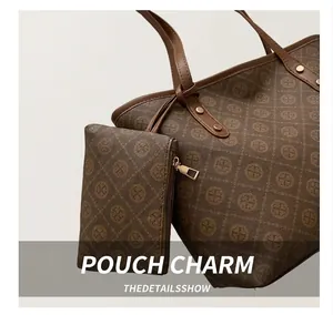 Detail of vintage monogram tote bag featuring leather handles and gold metal zipper hardware