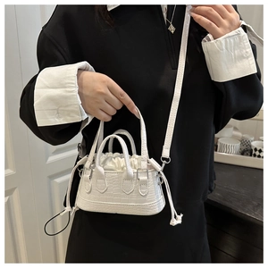 Vue détaillée d'un mini sac seau blanc à motif crocodile avec cordon et bandoulière