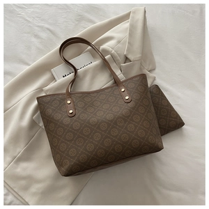 Detail view of the brown monogram tote bag set with matching inner pouch and gold hardware