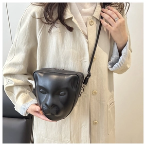 Détail de la tête de léopard 3D embossée sur un sac noir en similicuir avec boucles argentées