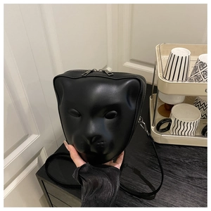 Detailed macro view of 3D cat face embossed pattern on matte black leather crossbody bag
