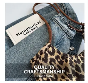 Detail showing the leopard print fabric texture and brown leather strap on the tote bag