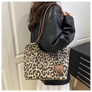 Detail of leopard print tote bag with brown straps and mini leather hanging pouch