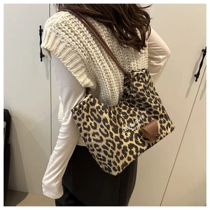 Détail du sac cabas à motif léopard avec lanières en cuir marron et texte C'est la vie