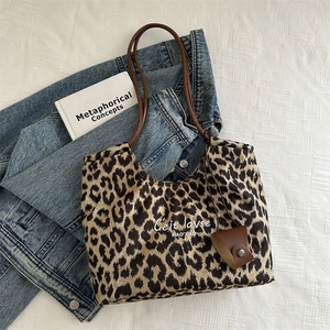 Large capacity vintage leopard print tote bag with brown straps on a denim jacket