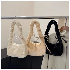 Close-up of fluffy faux fur shoulder bags in cream, apricot and black with bow details