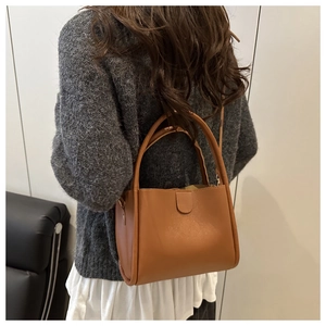 Brown lychee leather bucket bag shown from behind by a model for daily use