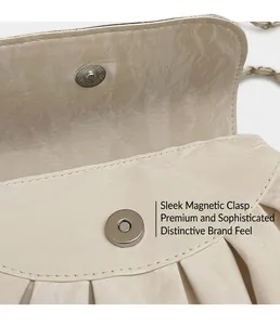 Detail of magnetic snap closure and ruched ivory faux leather texture on the bag