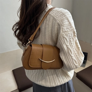 Sac sous le bras marron à motif crocodile avec fermoir doré porté par le mannequin
