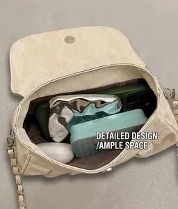 Detail view of the spacious inner compartment of the ruched chain crossbody bag