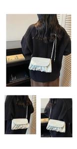 Detail of mint green pleated cloud bag with silver chain strap and smooth texture