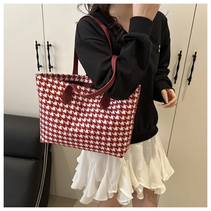 Detail of red and white houndstooth tote bag with premium leather handles and stitching