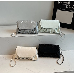 Detail showing pleated cloud bags in silver, mint green, cream white, and black leather
