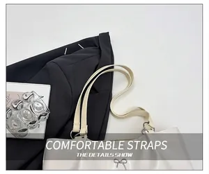 Detail view of comfortable shoulder strap and silver bow charm on beige tote bag