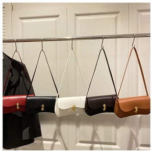 Row of minimalist leather baguette bags in five colors with elegant gold hardware