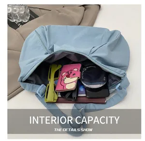 Internal view of a spacious blue nylon crossbody bag filled with daily essentials